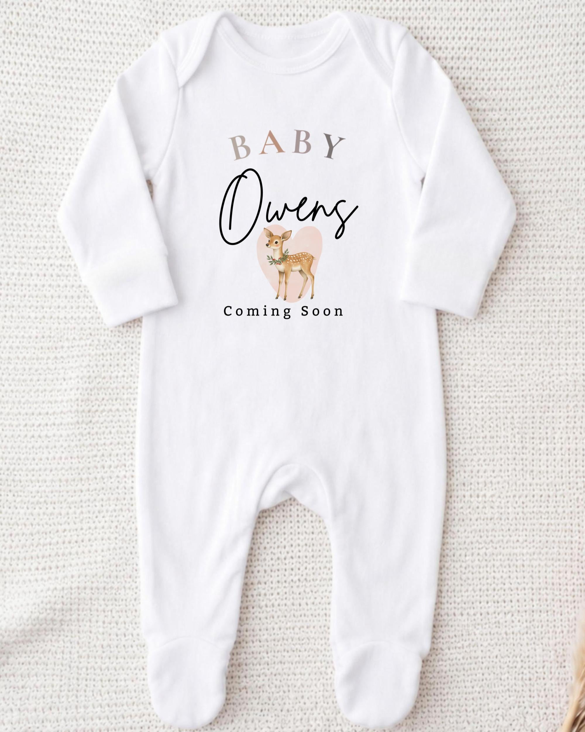 A white onesie with text and an illustration of a deer on it.