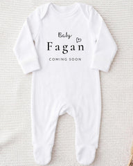 A white onesie with the text "Baby Fagan" and "Coming soon" printed on it.