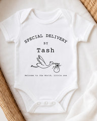 A white baby onesie with text and a graphic design, placed on a white surface.
