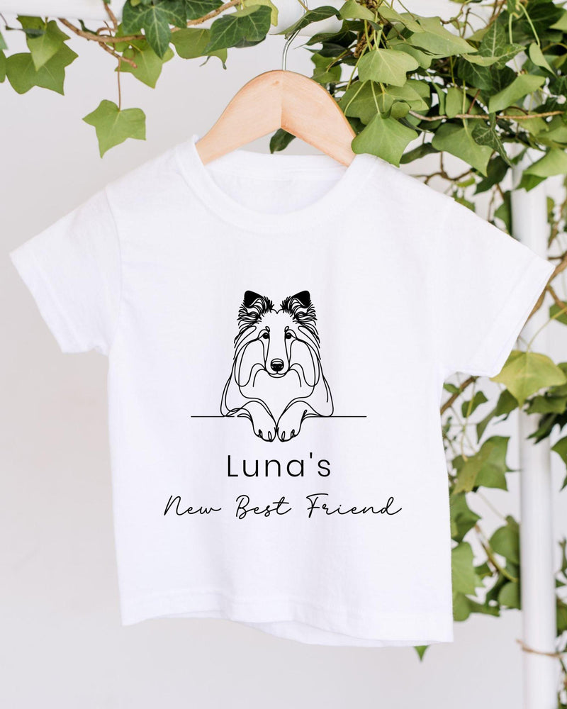 A white t-shirt with a black graphic design of a dog's face and the text "Luna's New Best Friend" printed on it.