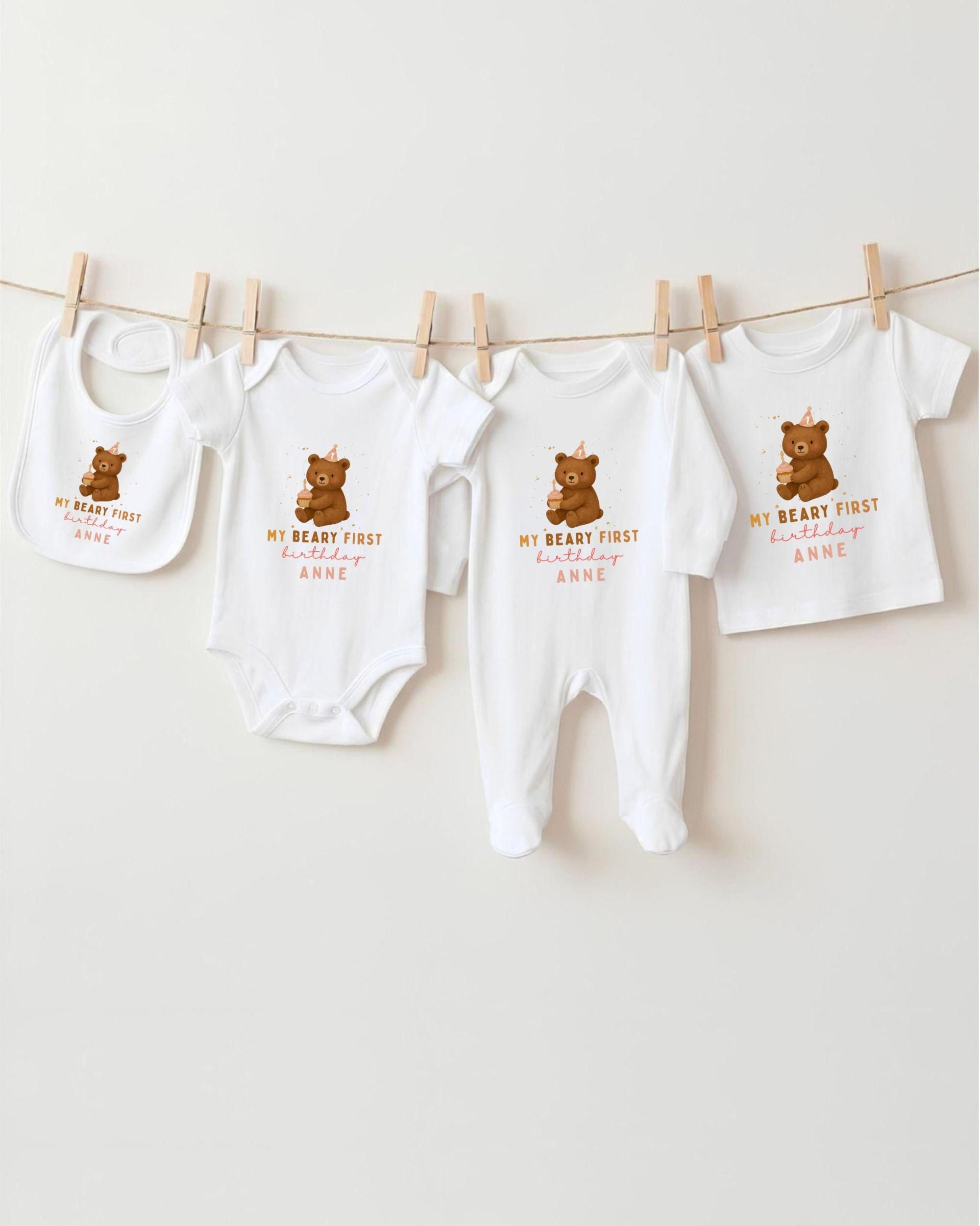A row of white baby clothes with brown bear designs, each with a personalized message printed on it.