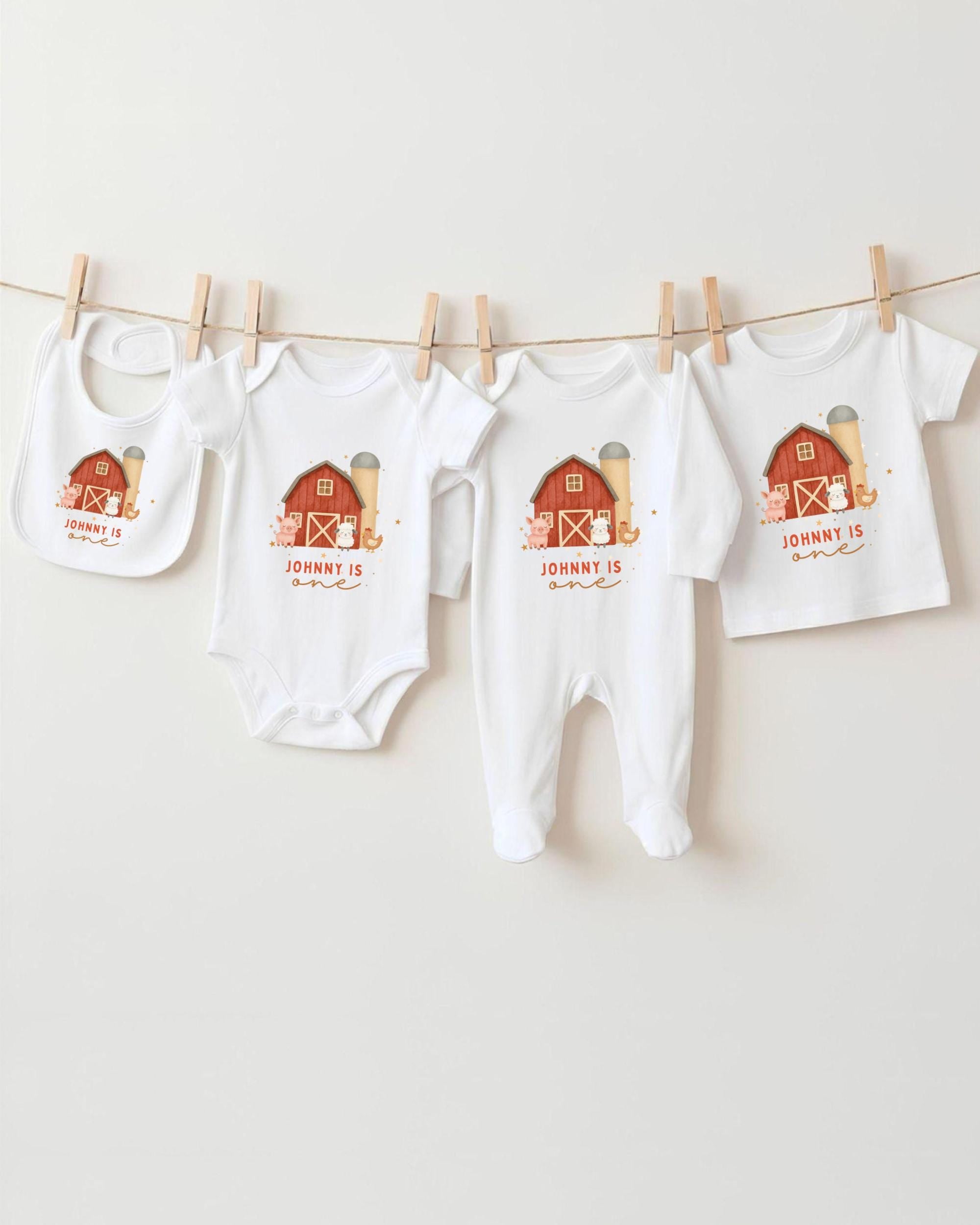 A collection of white baby clothes, including onesies and bibs, hanging on a clothesline.