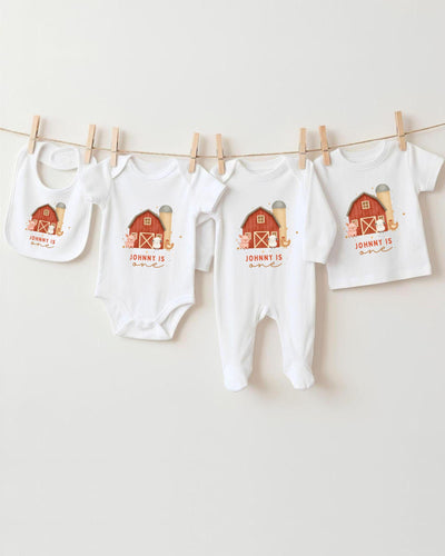 A collection of white baby clothes, including bodysuits and bibs, hanging on a clothesline.