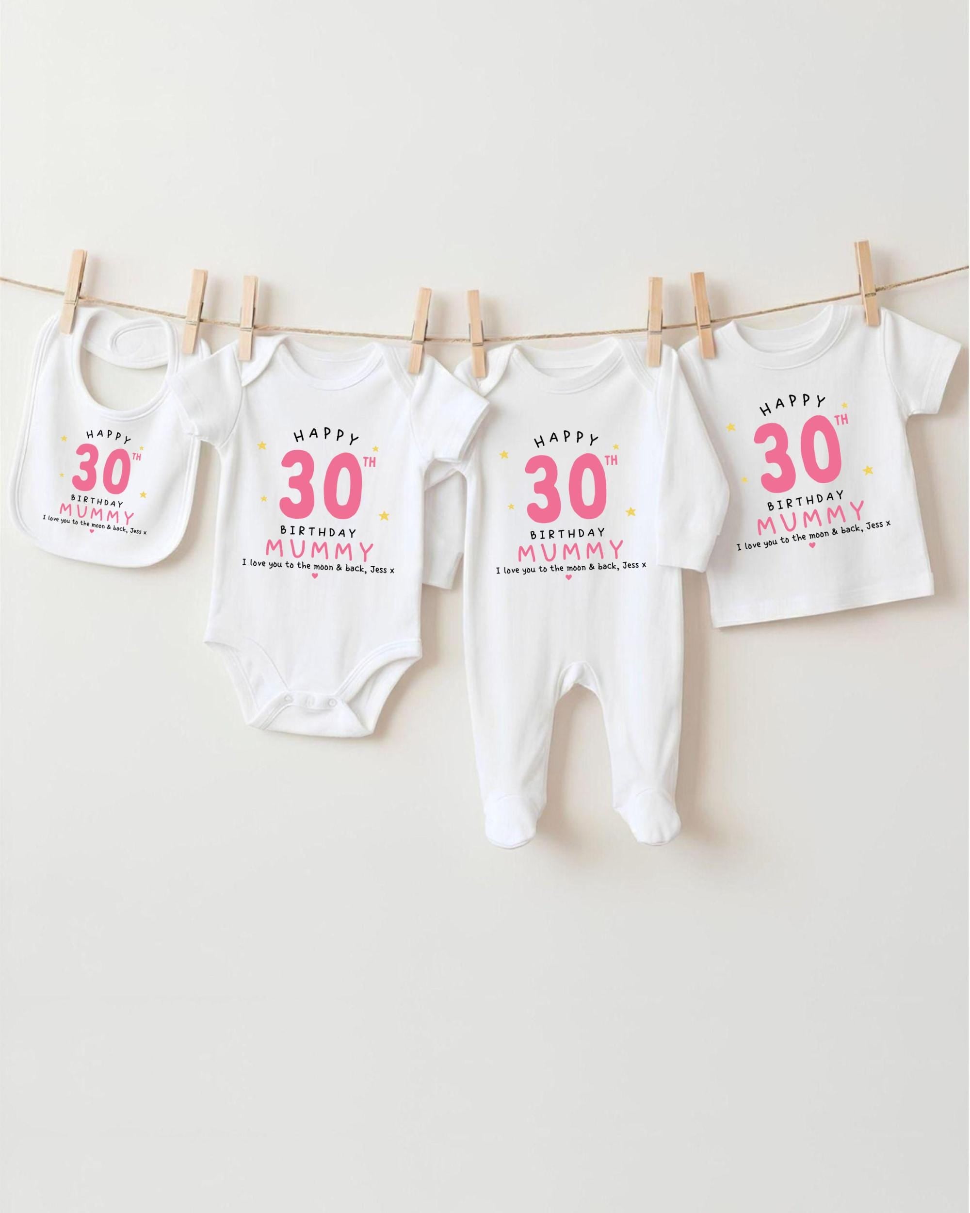 A row of white baby clothes with pink text and numbers, celebrating a 30th birthday for a mother.