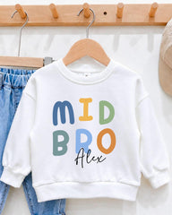A white sweatshirt with the text "MID BRO Alex" printed on it, hanging on a wooden hanger.