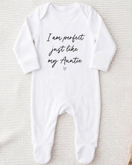 A white onesie with the text "I am perfect just like my Auntie" printed on it.