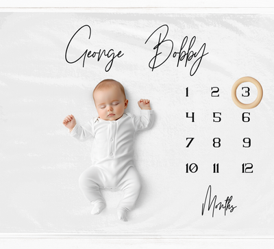 a baby is laying down on a calendar