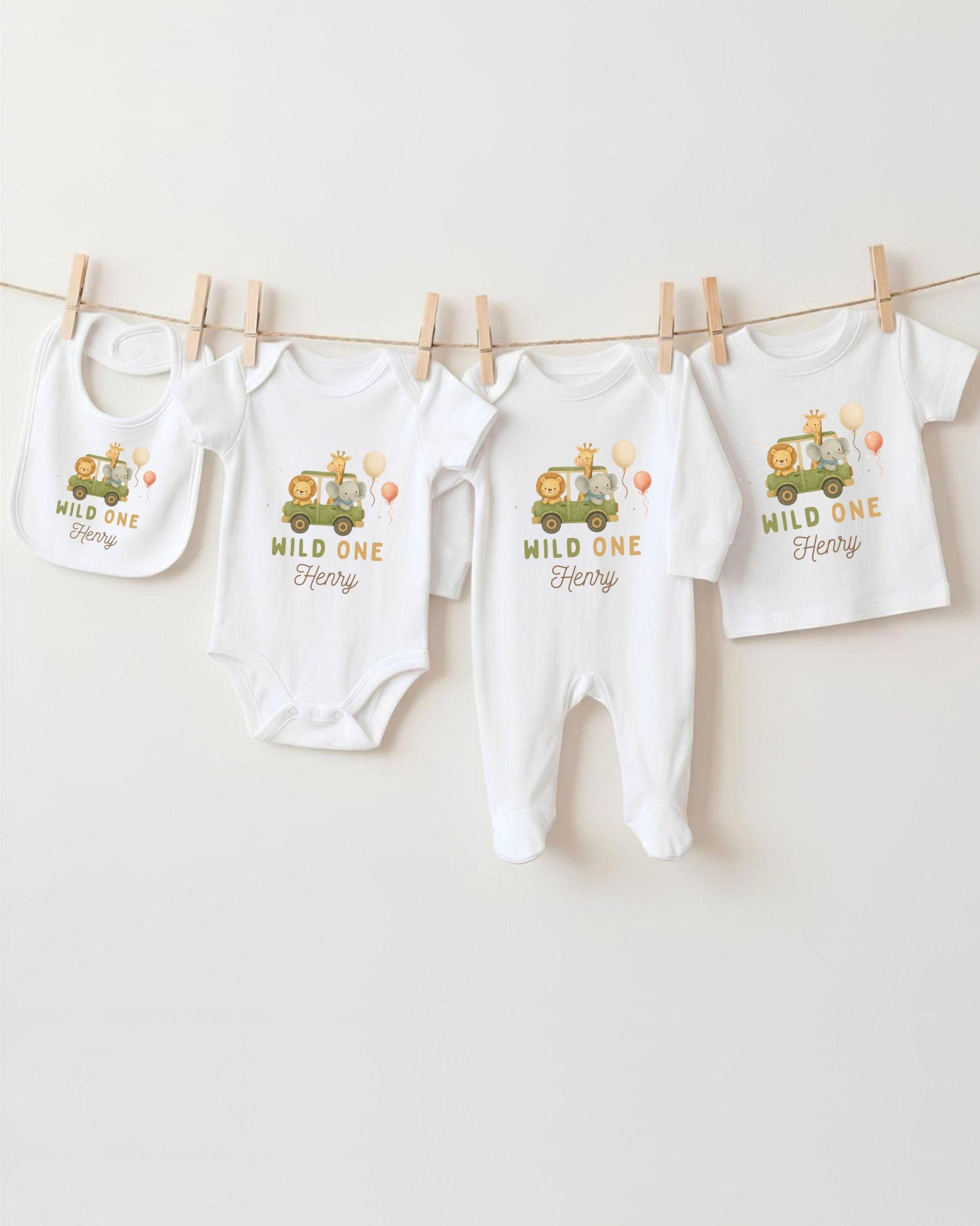 A collection of white baby clothes, including onesies and bibs, hanging on a clothesline.