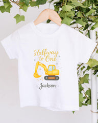 A white t-shirt with a yellow construction vehicle graphic and the text "Halfway to One - Jackson" printed on it.
