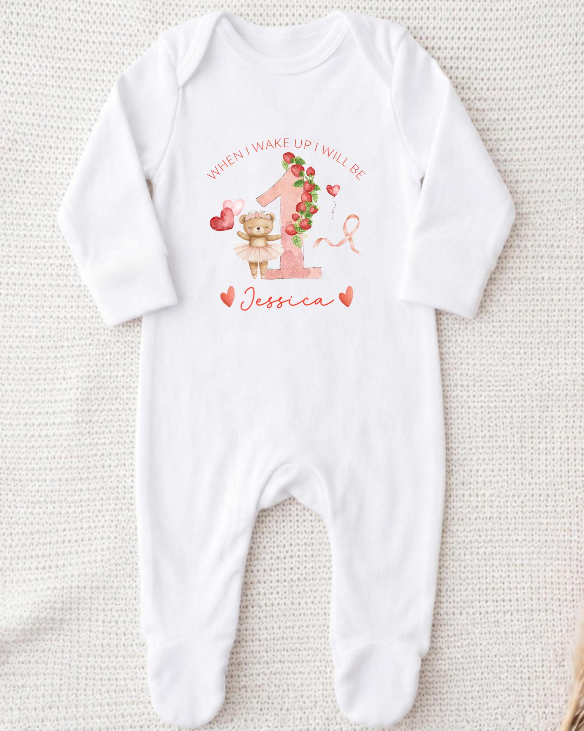A white onesie with a personalized message and a cute illustration of a teddy bear.