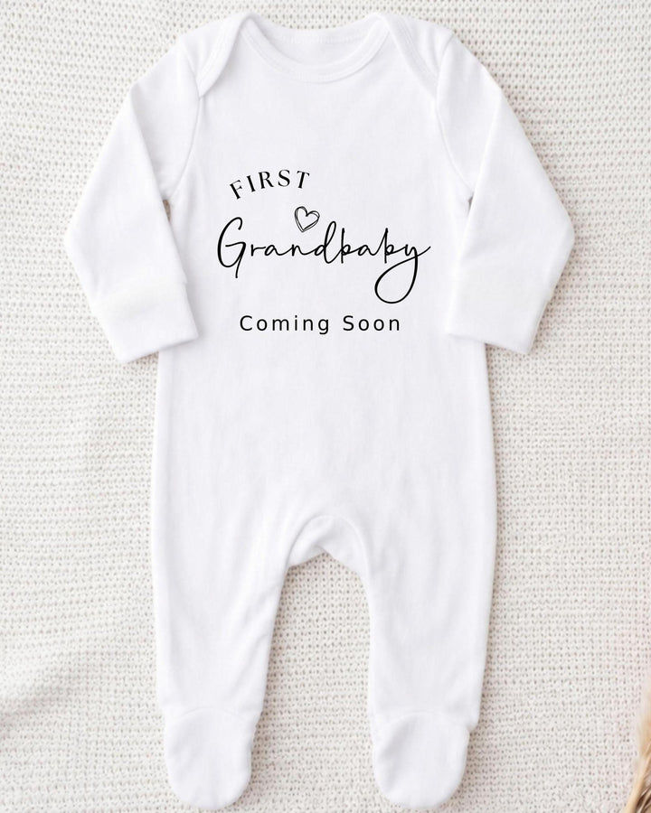 Personalised white Bib with black 'First Grandbaby Coming Soon' lettering and an outline heart for a grandparents pregnancy announcement.
