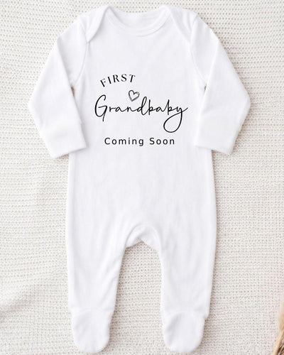 Personalised white Bib with black 'First Grandbaby Coming Soon' lettering and an outline heart for a grandparents pregnancy announcement.