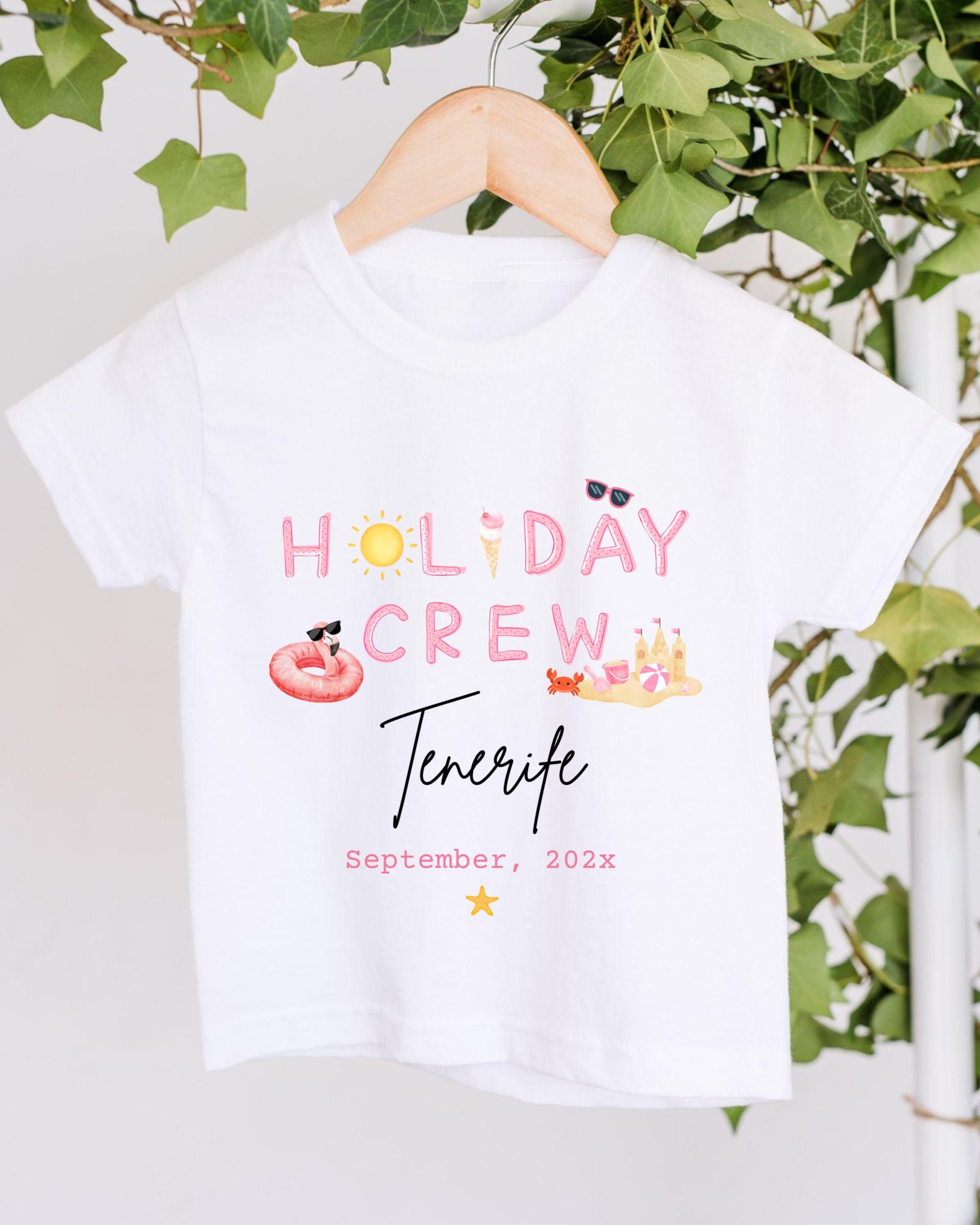 A white t-shirt with the text "HOLIDAY CREW Tenerife" printed on it, along with various summer-themed illustrations such as sunglasses, a beach ball, and a hot dog.