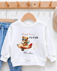 A white sweatshirt with a cartoon image of a bear piloting a plane and the text "First Time Flyer Mike" printed on it.