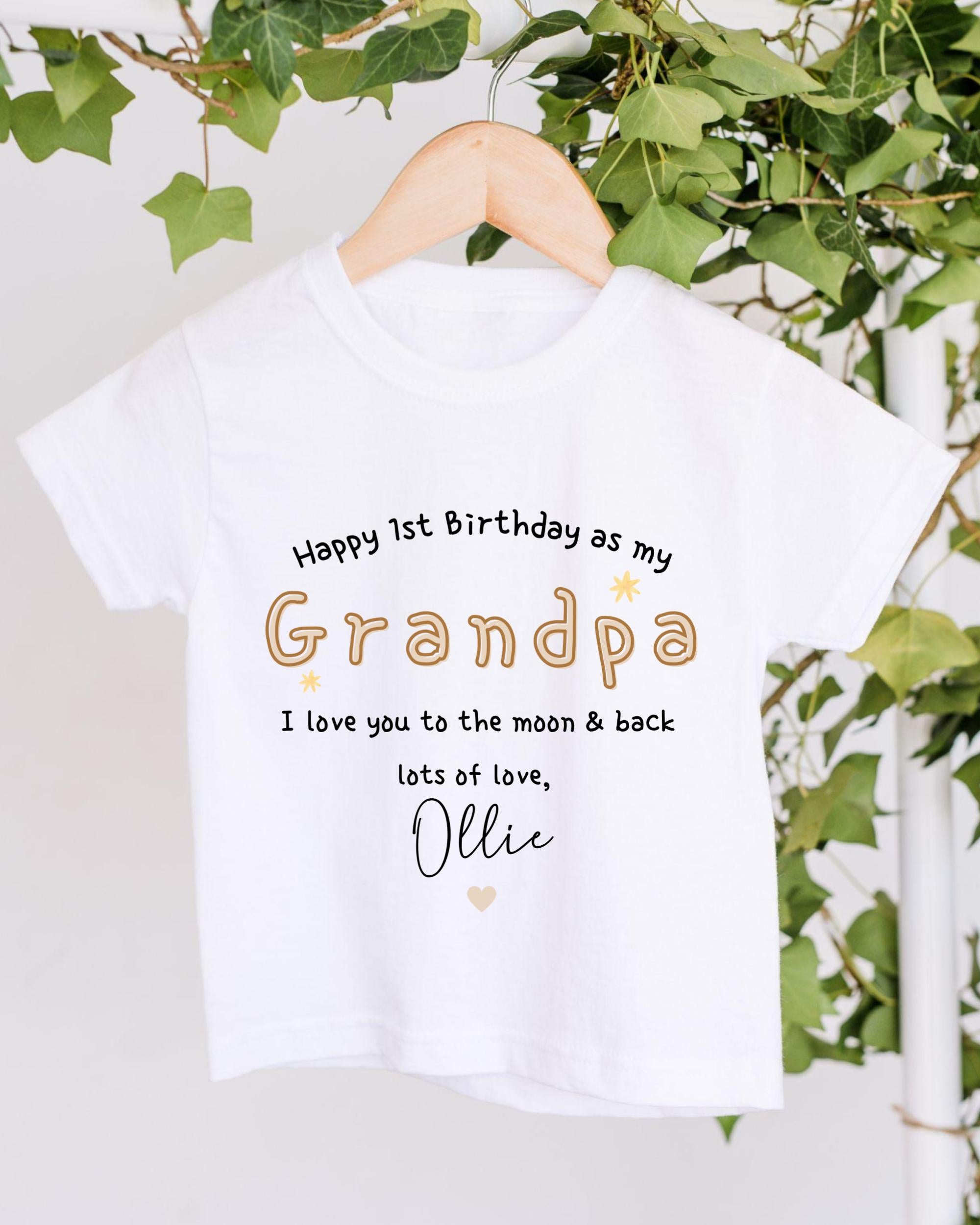 A white t-shirt with a personalized message printed on it, hanging on a wooden hanger.