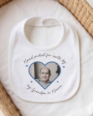 A white bib with a printed photo of an older man and the text "Hand picked for earth by my Grandpa in Heaven" printed on it.