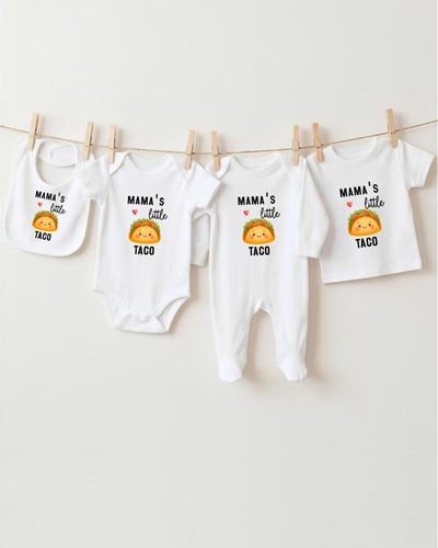 A row of four white baby onesies with the text "MAMA'S LITTLE TACO" printed on them, along with a small cartoon taco.