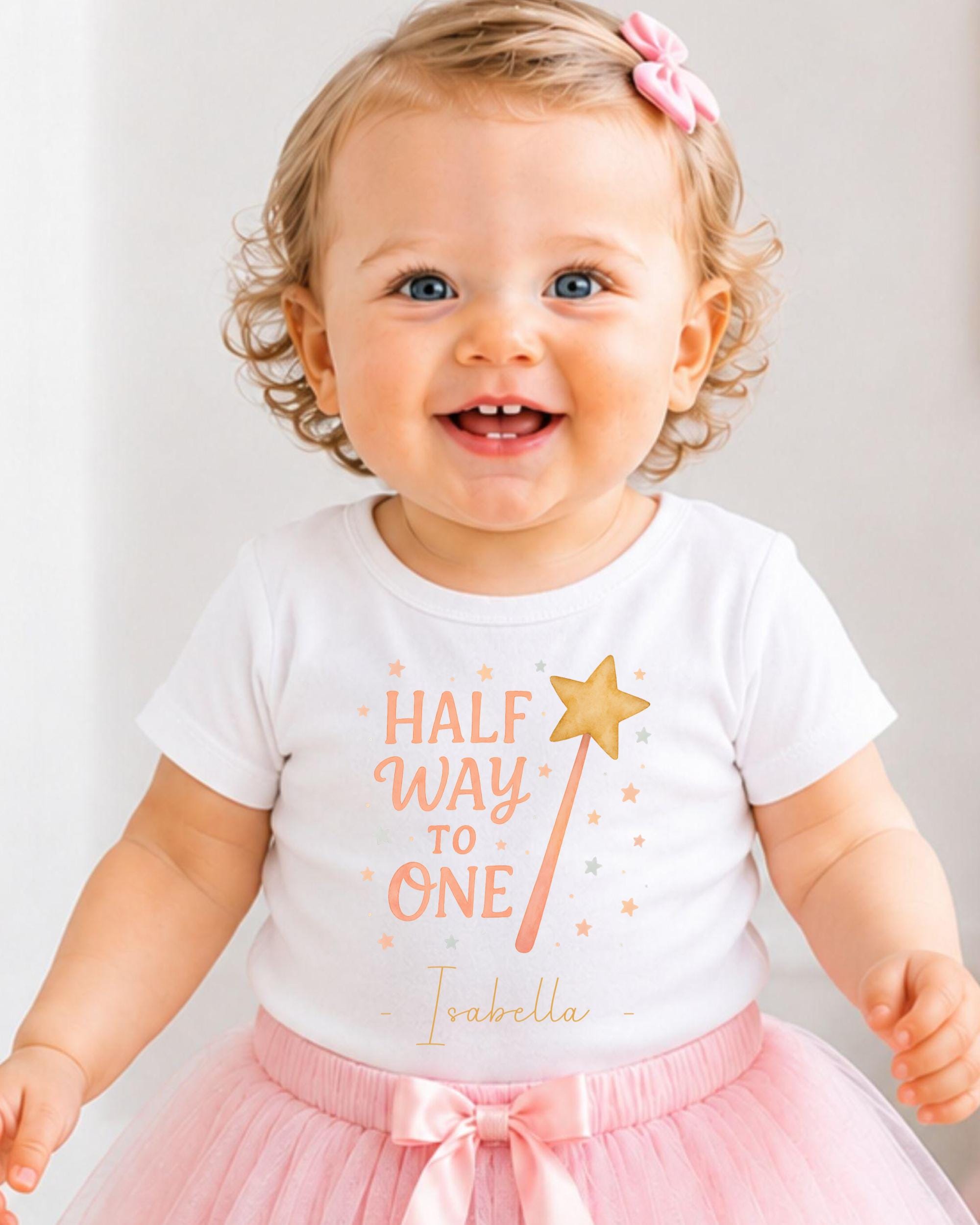 A smiling baby girl wearing a white t-shirt with a personalized message and a pink tutu skirt.