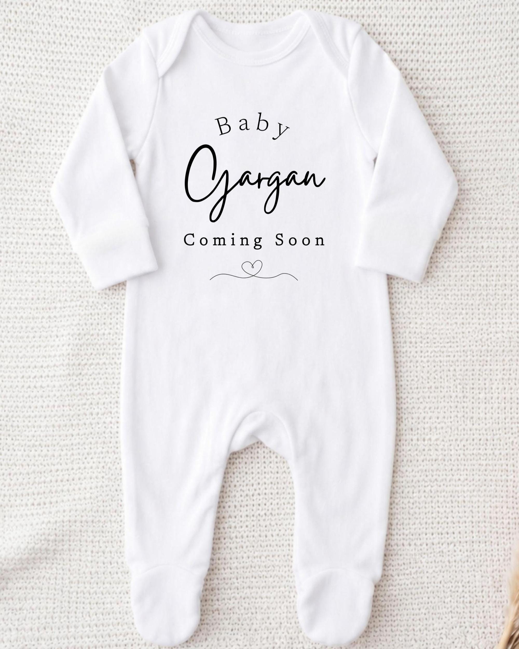 A white onesie with the text "Baby Gargan Coming Soon" printed on it.
