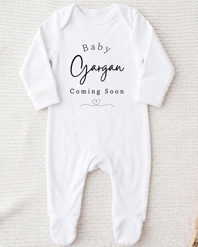 A white bodysuit with the text "Baby Gargan Coming Soon" printed on it.
