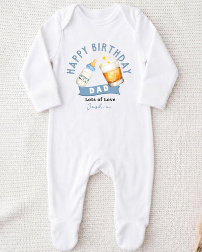 A white onesie with a birthday message and illustrations of a bottle of milk and a glass of beer.