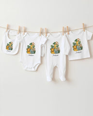A collection of baby clothes, including onesies and bibs, hanging on a clothesline.