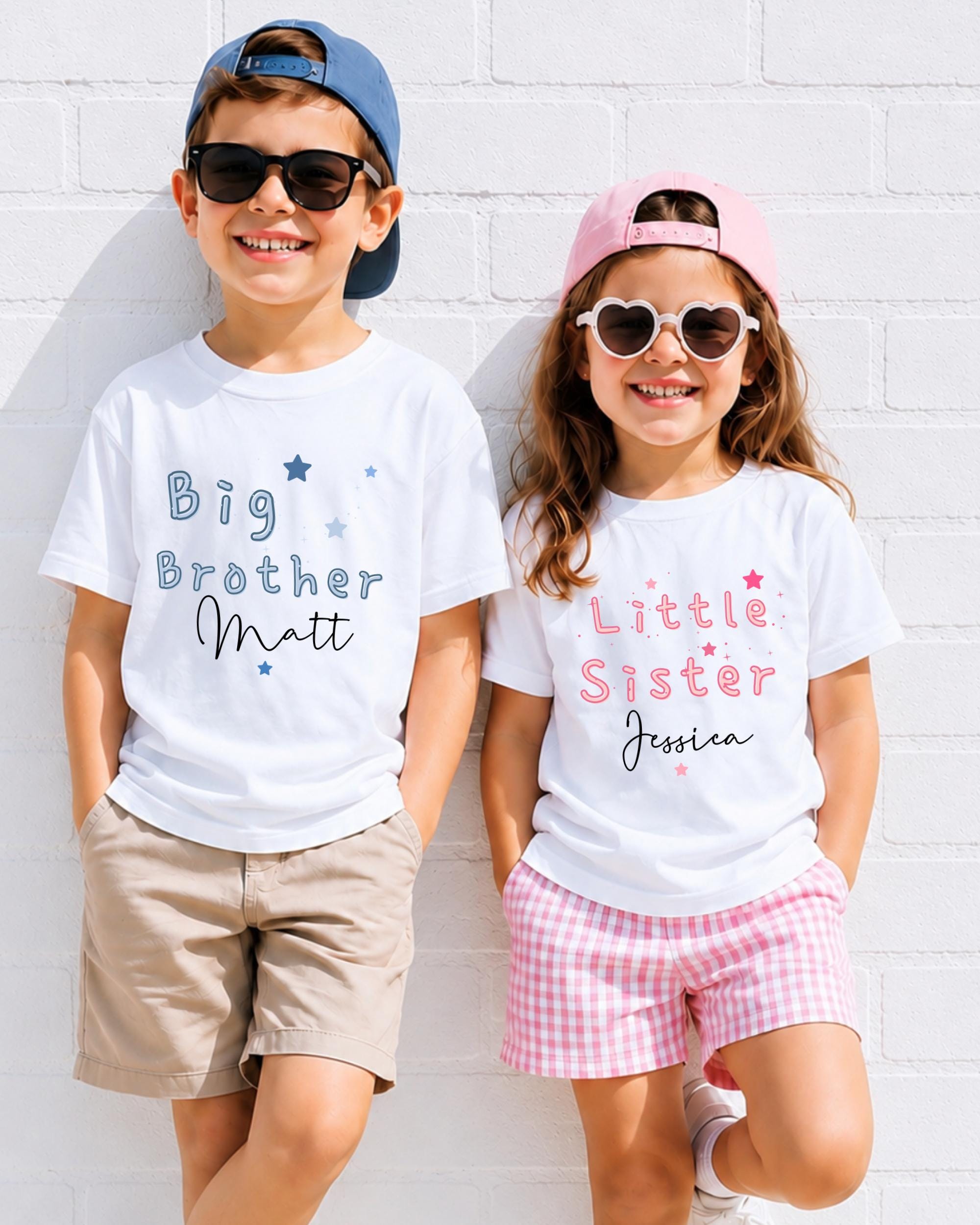 Two children, a boy and a girl, are standing against a white brick wall, smiling and wearing matching white t-shirts with text that says "Big Brother Matt" and "Little Sister Jessica".