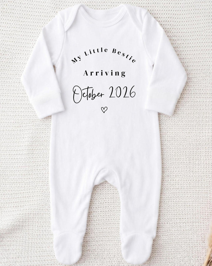 Personalised white Baby Vest with black 'My Little Bestie Arriving October 2026' lettering and a small outline heart for a pregnancy announcement.