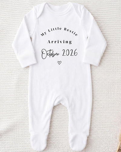 Personalised white Baby Vest with black 'My Little Bestie Arriving October 2026' lettering and a small outline heart for a pregnancy announcement.
