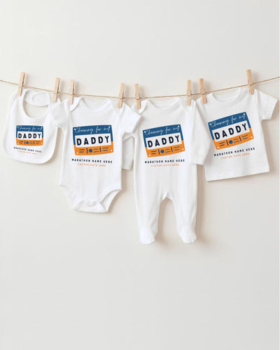 a collection of baby clothes, including onesies and bibs, hanging on a clothesline.