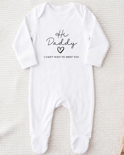 White Baby Grow with black script 'Hi Daddy', an outlined heart and small block 'I can't wait to meet you' lettering.