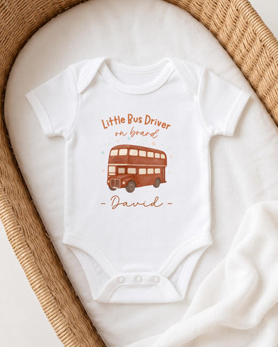 A white onesie with a printed image of a double-decker bus and the text "Little Bus Driver on board David" printed on it.