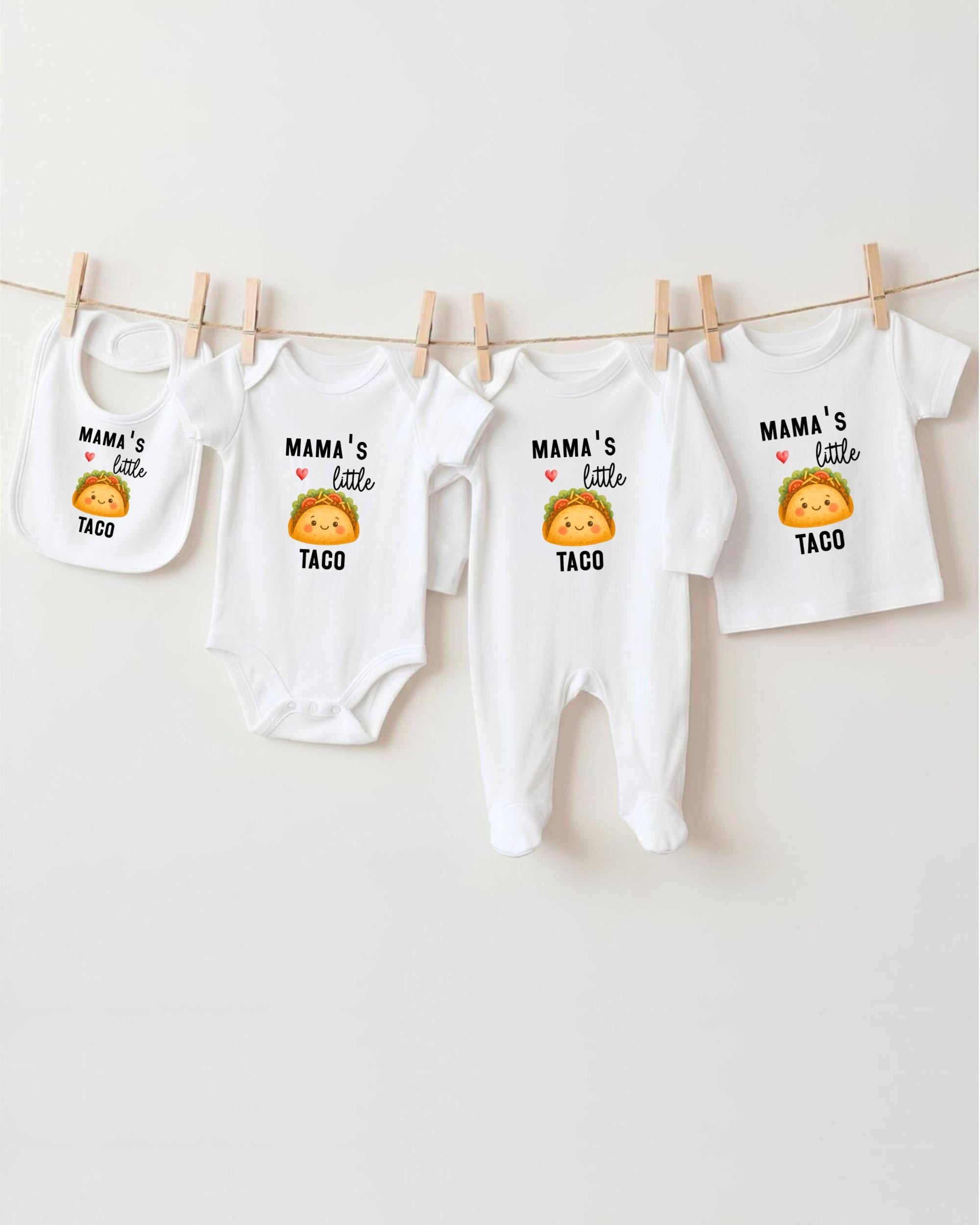 A row of four white baby onesies with the text "MAMA'S LITTLE TACO" printed on them, along with a small cartoon taco.