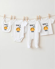 A row of four white baby onesies with the text "MAMA'S LITTLE TACO" printed on them, along with a small cartoon taco.
