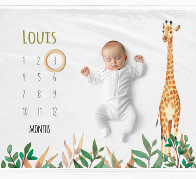 a baby is laying on a calendar with a giraffe