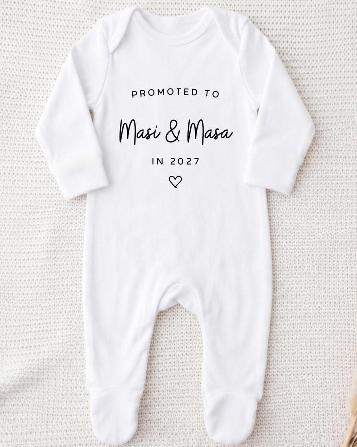 Personalisable white Baby Grow with black 'Promoted to Masi & Masa In 2027' block and script lettering and an outlined heart.