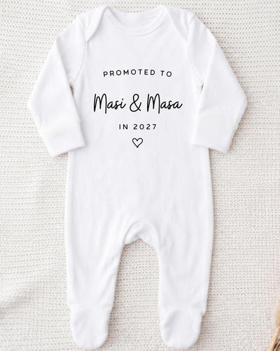 Personalisable white Baby Grow with black 'Promoted to Masi & Masa In 2027' block and script lettering and an outlined heart.