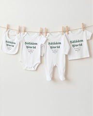 A row of white baby clothes with the text "Saläm World" printed on them, hanging on a clothesline.