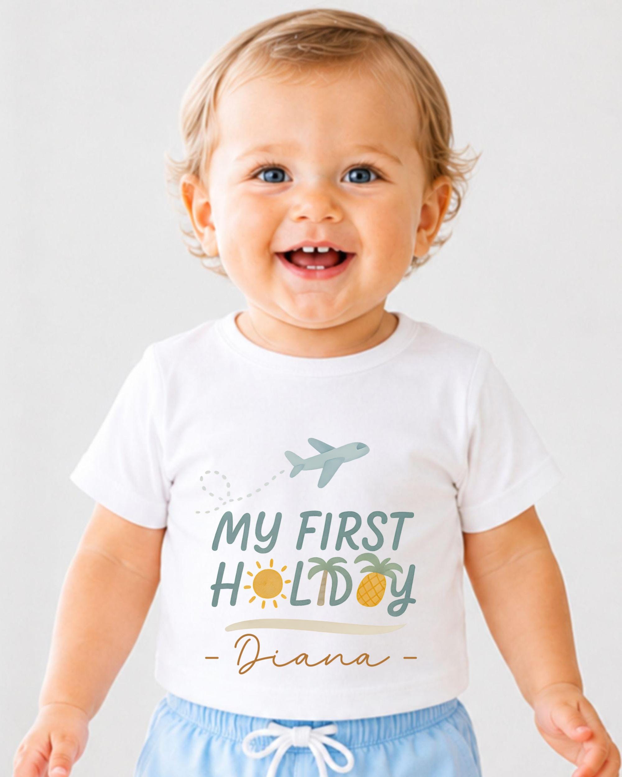 A smiling baby wearing a white t-shirt with a graphic design and text.