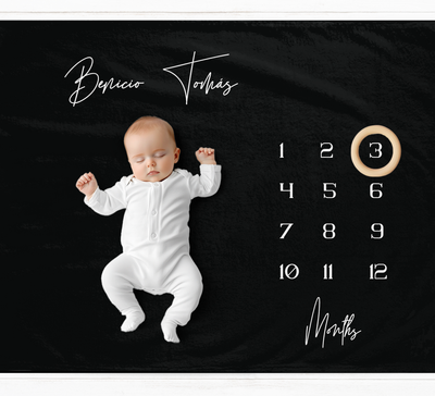 a baby is laying down on a calendar