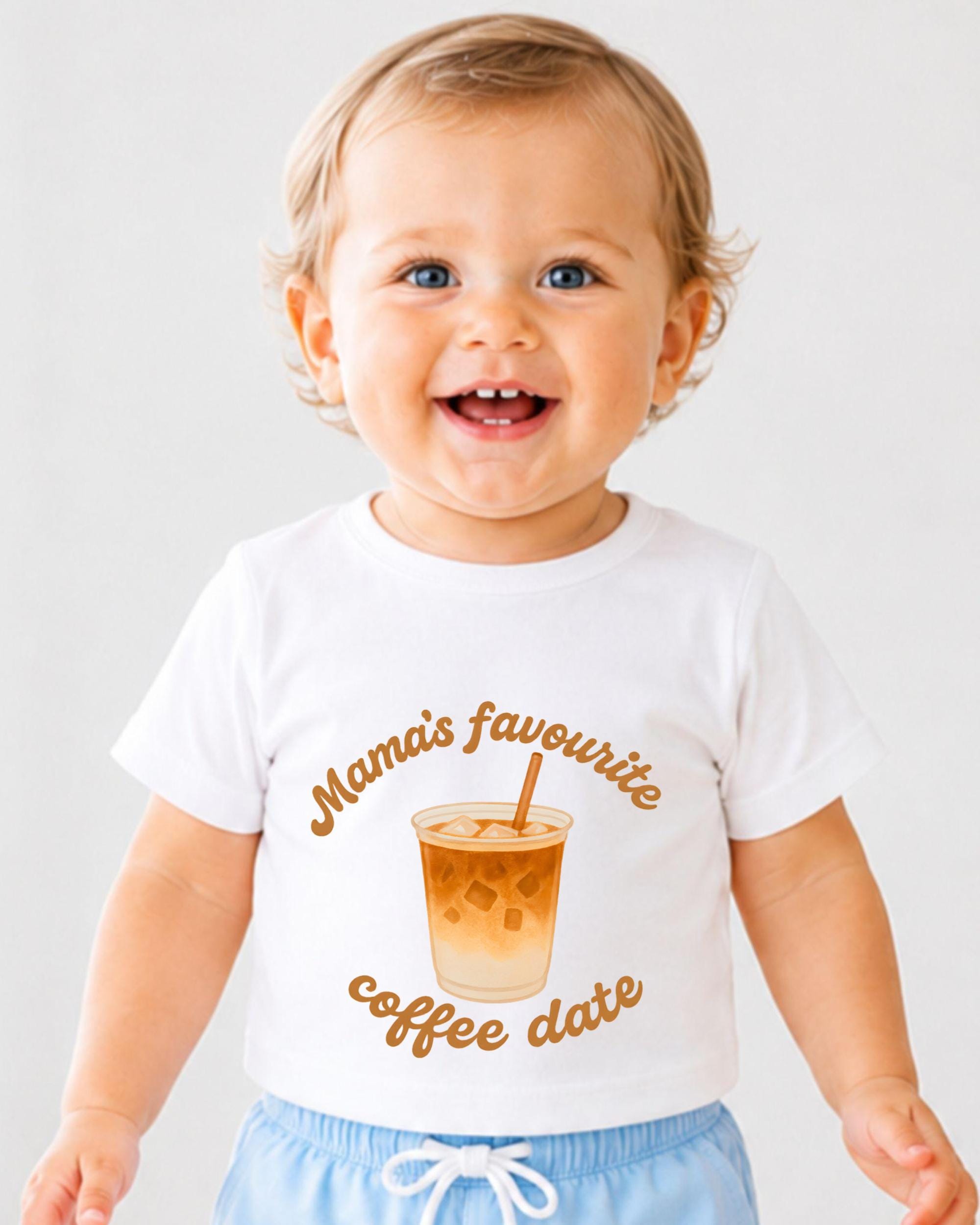 A smiling baby wearing a white t-shirt with a graphic of a coffee cup and the text "Mama's favourite coffee date" printed on it.