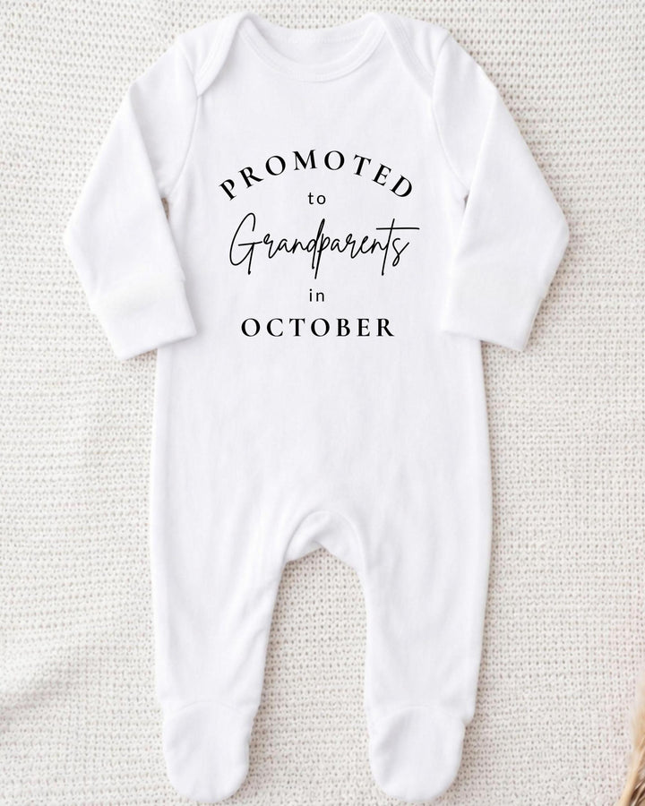 Personalisable white Baby Grow with black 'Promoted to Grandparents in October' curved serif and script lettering.