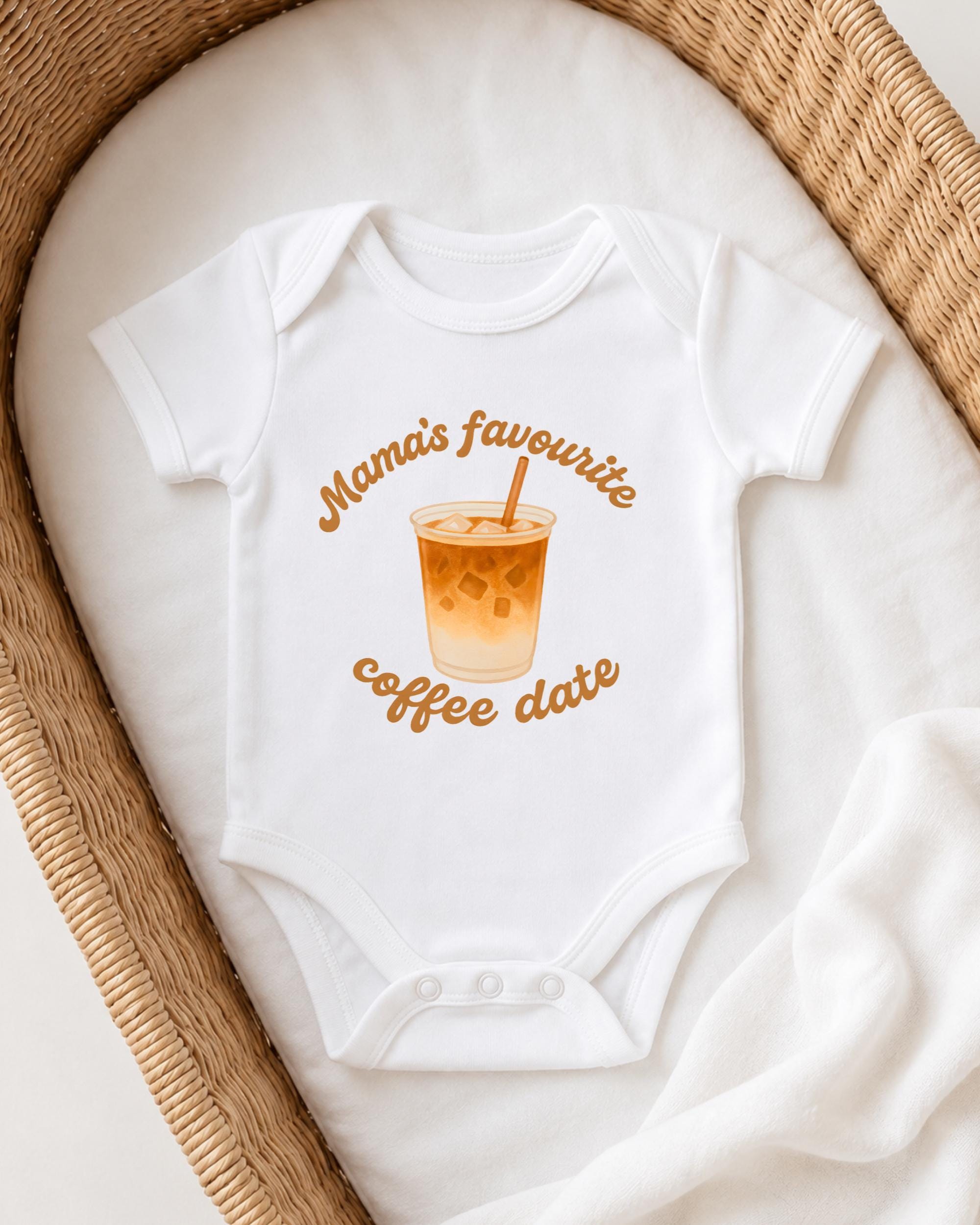 A white onesie with a graphic of a coffee cup and the text "Mama's favourite coffee date" printed on it, placed on a white blanket.