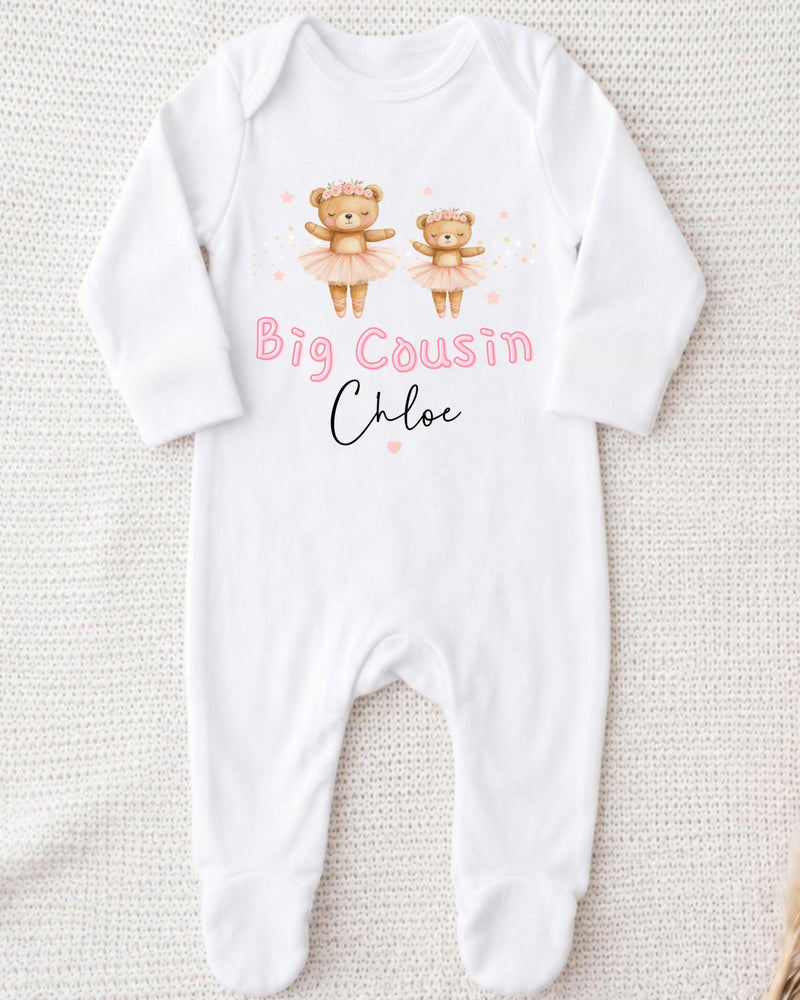 A white onesie with a design of two teddy bears in tutus and the text "Big Cousin Chloe" printed on it.