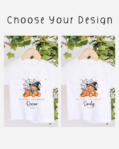 two white t-shirts with a teddy bear and a spider web design, hanging on a wooden hanger. The text on the t-shirts reads "My first Halloween Oscar 2020" and "My first Halloween Emily 2020", indicating the names of the babies.