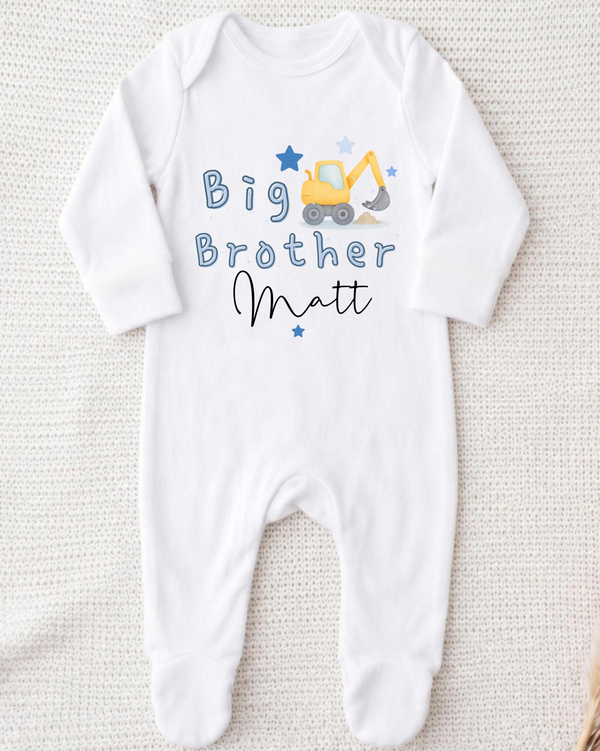 A white onesie with a blue construction vehicle and the text "Big Brother Matt" printed on it.