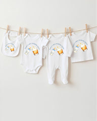 A collection of baby clothes, including onesies and bibs, hanging on a clothesline.