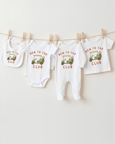 A row of four white baby clothes with the text "NEW TO THE CLUB" printed on them, along with a golf cart graphic.