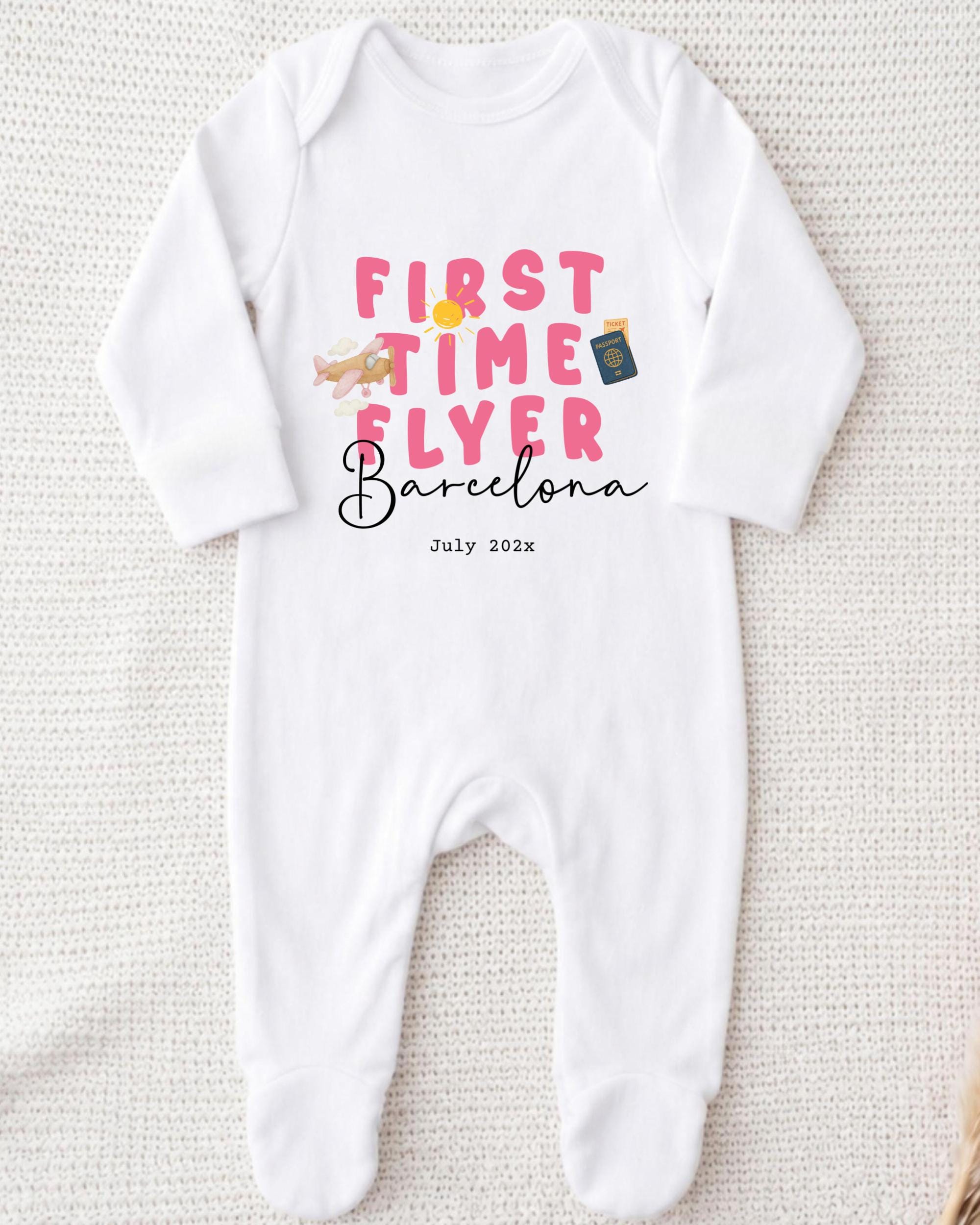 A white onesie with pink text and graphics printed on it.