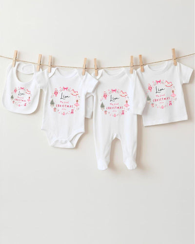 A row of four white baby clothes, including bodysuits and bibs, hanging on a clothesline.